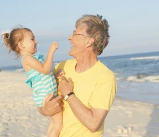 Man holding baby on Gulf Shores Al beach