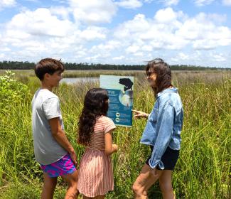 Family reading a sign inside Gulf State Park