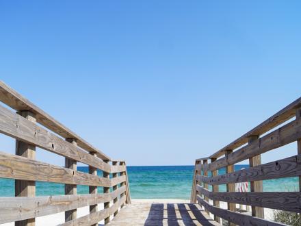View of the Gulf of Mexico under clear weather from a wooden boardwalk leading to the beach at Gulf Shores.