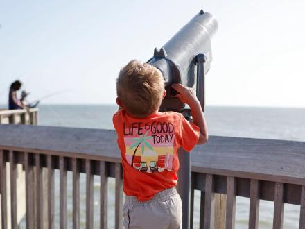 Little boy looking through telescope