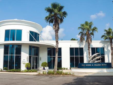 Gulf Shores Welcome Center with palm trees and modern architecture, dedicated to enhancing your Gulf Shores vacation experience.