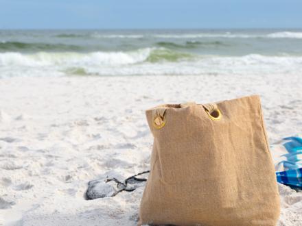 Beach Bag on the sandy shore of Gulf Shores & Orange Beach, showcasing essential packing tips for a beach trip.