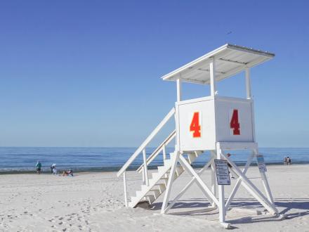 Lifeguard stand on a pristine beach in Alabama Beaches, providing information on Gulf Shores beach conditions for a safe and relaxing vacation