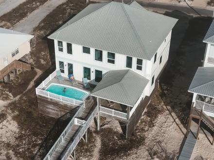 Aerial view of a luxurious vacation rental house with a pool in Gulf Shores, perfect for family stays when visiting Alabama Beaches.