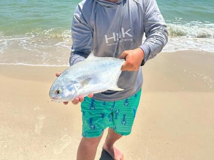 Man holding pompano caught surf fishing in Orange Beach