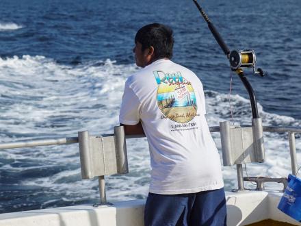 Man on back of a charter boat in the Gulf of Mexico, fishing charter in Orange Beach