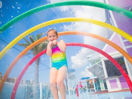 Young girl playing in the free splash pad at Surf Style in Orange Beach