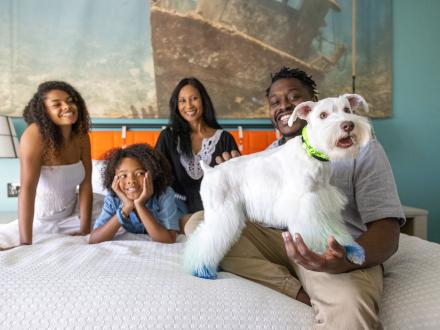 Family with dog in hotel room at Hotel Indigo, pet-friendly hotel in Orange Beach