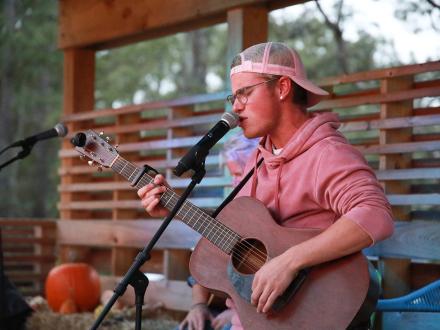 Singer performing at Woodside Restaurant during Frank Brown International Songwriters Festival