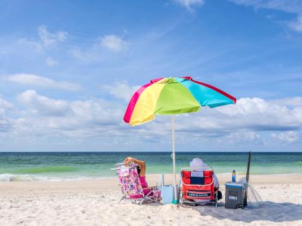 Couple sitting under an umbrella on the beach in Gulf Shores