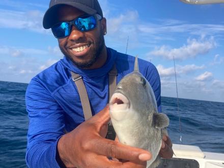 Angler holding a triggerfish caught on a fishing charter in Orange Beach