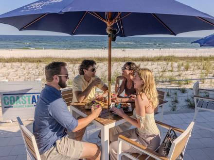 Friends dining at a table at Coastal beachfront restaurant