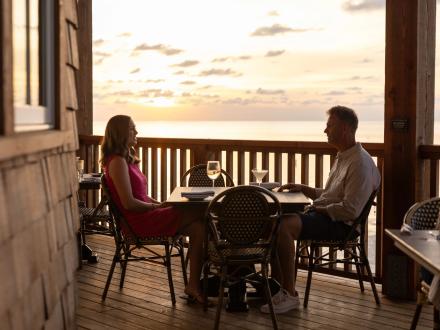 Couple dining at sunset at Jesse's on the Bay restaurant in Fort Morgan, Alabama
