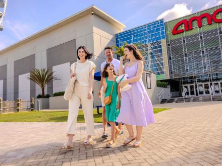 Family walking in front of the AMC Movie Theater at The Wharf in Orange Beach