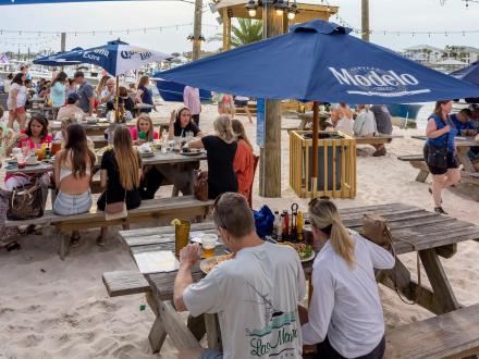 People dining by the water at Flora-Bama Yacht Club in Orange Beach