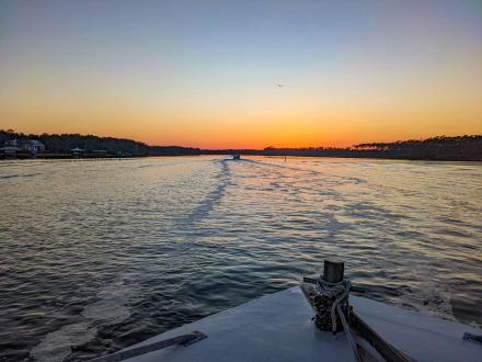 View of the sun setting on the water from a boat on Alabama's Beaches