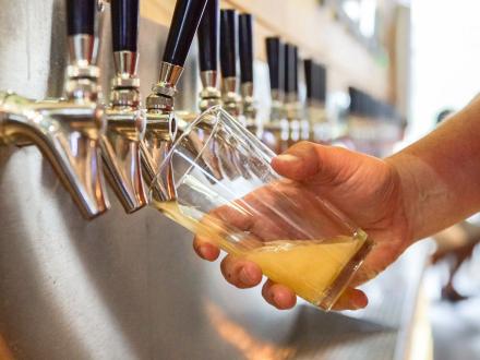 Hand pouring a beer at Pour Smart Bar at The Wharf
