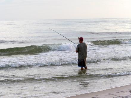 Man in the surf fishing in the Gulf in Orange Beach