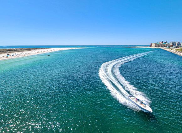Boat going through the scenic Perdido Pass in Orange Beach, Alabama, perfect for planning a family vacation.