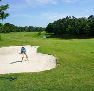 A man goes golfing after planning for his vacation at Gulf Shores and Orange Beach.