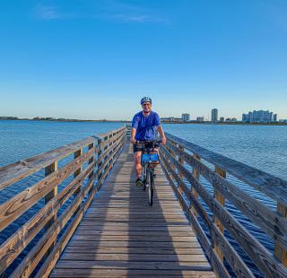 Cyclist riding along a scenic pier during a vacation to Gulf Shores, Alabama.